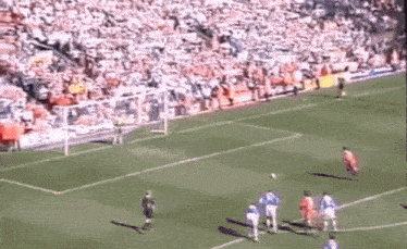 a soccer game is being played on a field with a crowd in the stands