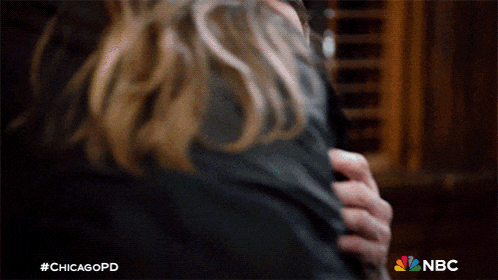 a close up of a person hugging another person with a nbc logo in the background