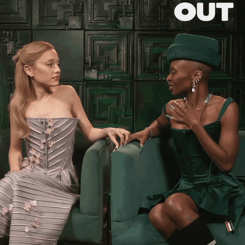 two women are sitting next to each other and the word out is on the bottom