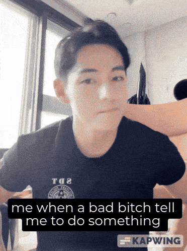 a man in a black shirt with the words me when a bad bitch tell me to do something