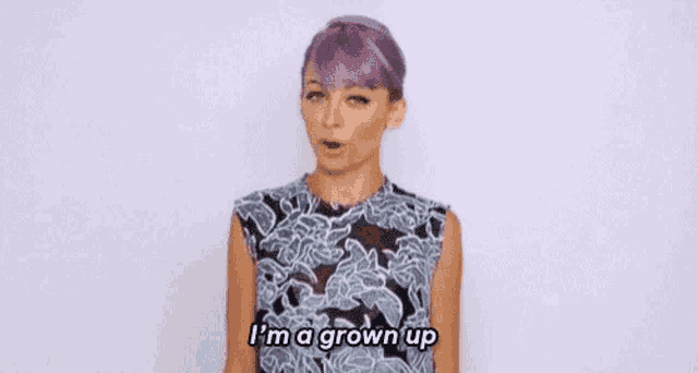 a woman with purple hair is wearing a floral dress and says `` i 'm a grown up ''
