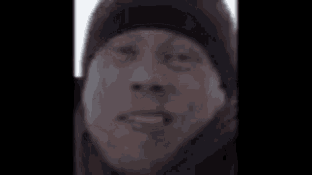 a close up of a person 's face with a black hat on