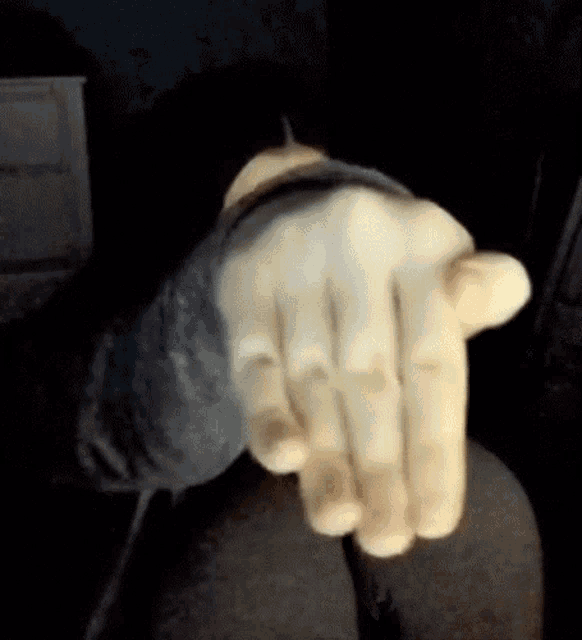 a close up of a person 's hand with a black sleeve