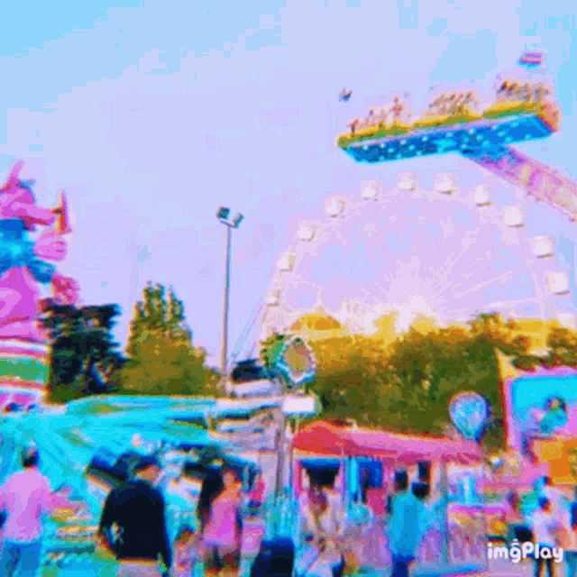 a blurry picture of a carnival with a ferris wheel in the foreground