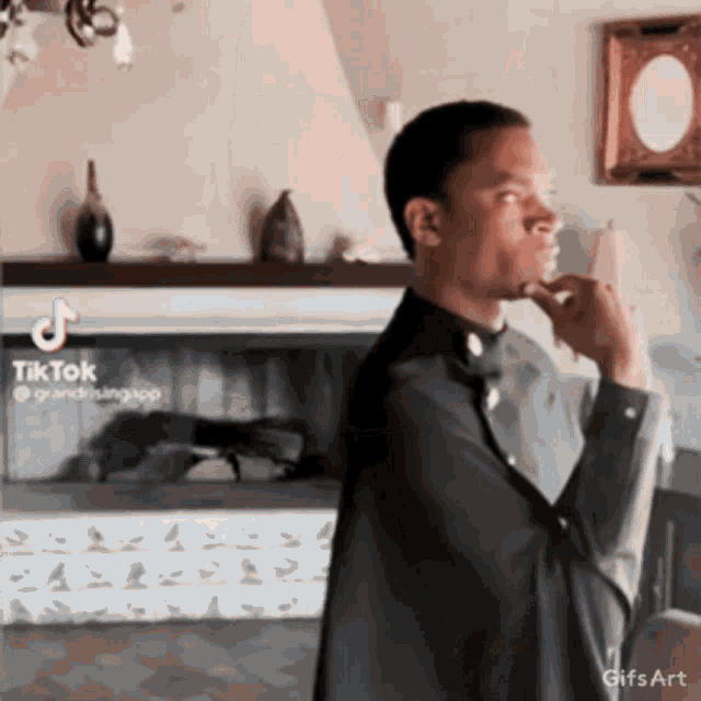 a man is standing in front of a fireplace with a tiktok watermark on the bottom right