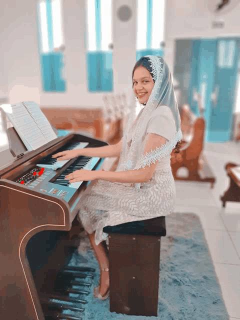 a woman in a white dress is playing an electronic organ