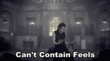 a man is dancing in a dark room with the words " can 't contain feels " on the bottom