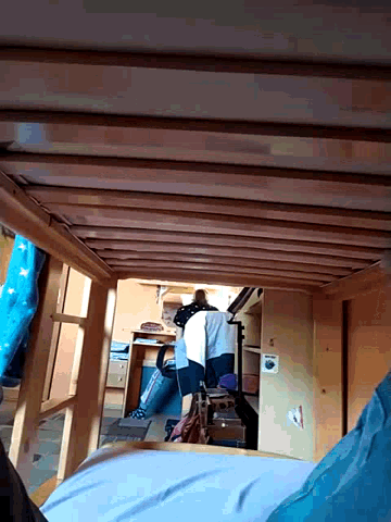 a person is sitting on a bunk bed with a sign on the wall that says ' a ' on it