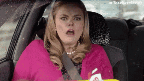 a woman is sitting in the back seat of a car with her mouth open and a surprised look on her face .