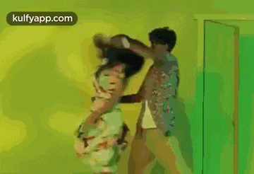 a man is holding a woman in his arms while they are dancing in a room .