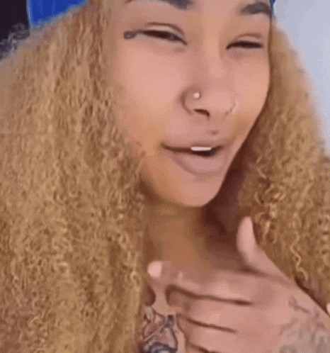 a woman with curly hair and a tattoo on her hand