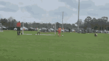 a soccer player wearing a number 11 jersey kicks the ball into the goal