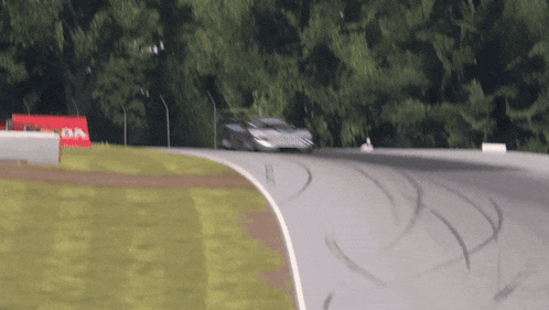 a blurred image of a race car on a track with a sign that says da on it
