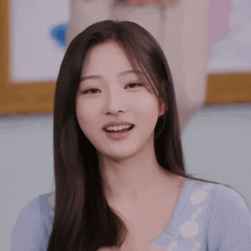 a young woman with long hair is smiling and looking at the camera .