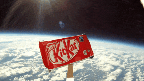 a nestle kitkat candy bar is floating in space