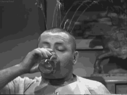 a man is drinking a glass of water with water pouring out of his head .