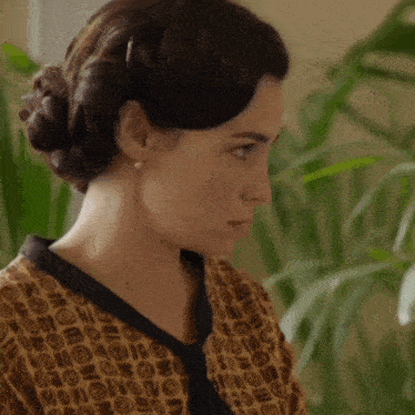 a woman with a bun on her head is wearing a tie