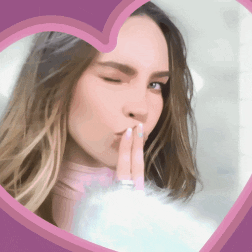 a woman blowing a kiss in a pink heart