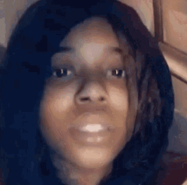 a close up of a young woman 's face with dreadlocks looking at the camera .