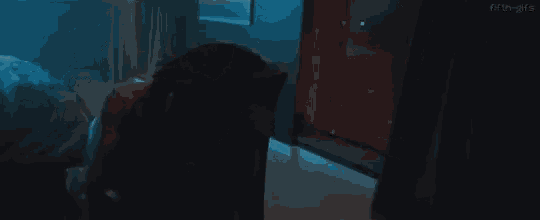 a woman is sitting in a chair in a dark room with her shirt off .