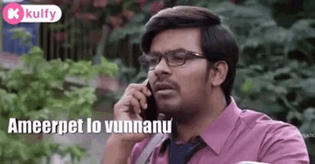 a man is talking on a cell phone while wearing glasses .