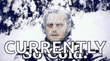 a man with ice on his face is standing in the snow with the words `` currently '' written below him .