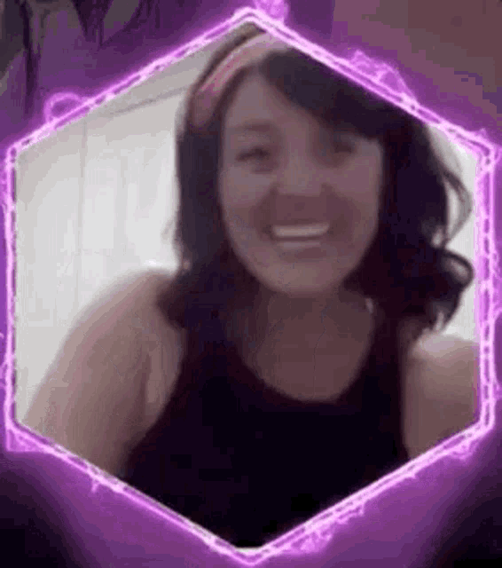 a woman in a black tank top is smiling in a purple hexagon .