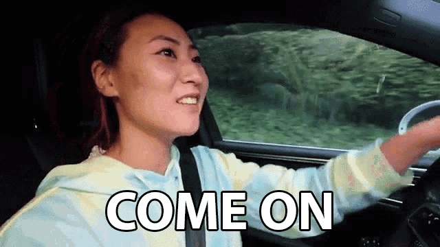 a woman is driving a car and the words come on are on the screen