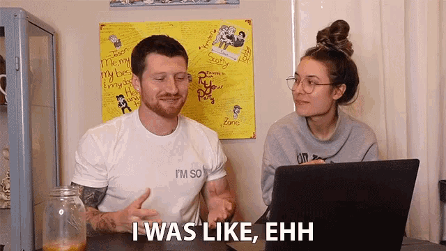 a man and a woman are sitting at a table with a laptop and the man says i was like ehh