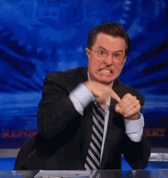 a man in a suit and tie is making a funny face .