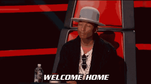 a man sitting in a chair with his arms outstretched and the words welcome home behind him