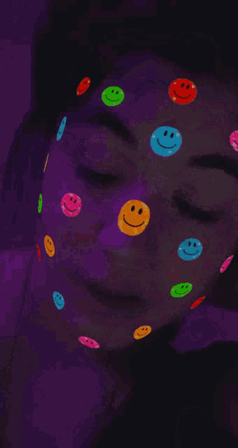 a woman with colorful smiley faces on her face
