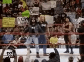 a group of people are standing in a wrestling ring with signs that say ecm