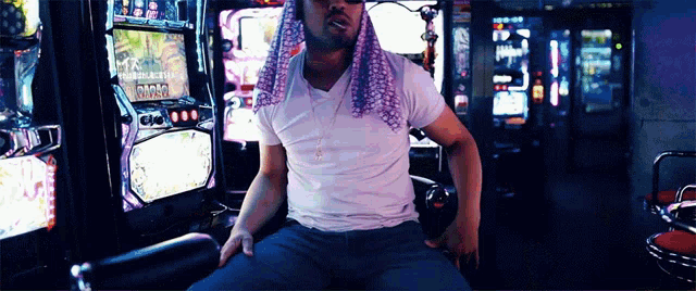 a man in a white shirt sits in front of a slot machine that says wild