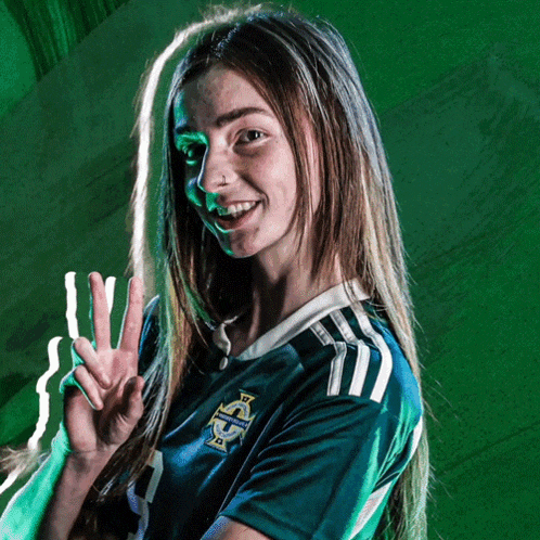 a woman wearing a green jersey with the letter s on the front