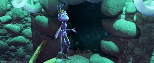a purple ant with a crown on its head is standing on a rock in a cave .