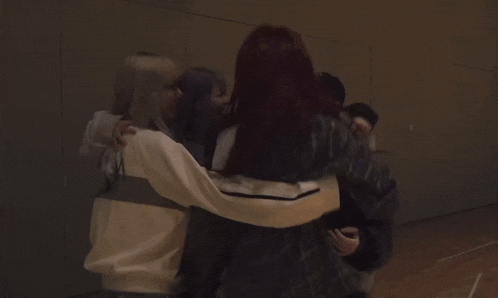 a group of people are standing in a dark room .