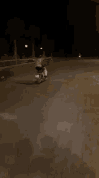 a man is riding a motorcycle down a street at night