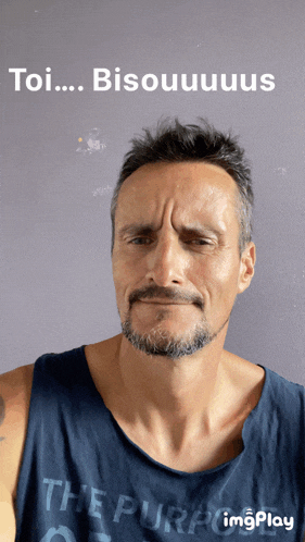 a man with a beard is wearing a blue tank top that says the purpose on it