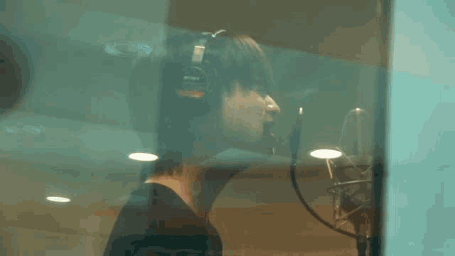 a person wearing headphones singing into a microphone