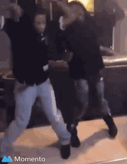 two people are dancing in a kitchen and the word momento is on the bottom