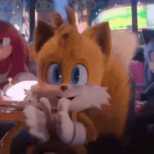 tails the fox from sonic the hedgehog is sitting at a table with a rabbit .