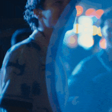 a blurry picture of a person in a dark room with a blue background