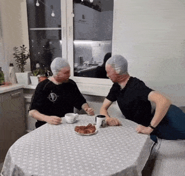 two men are sitting at a table with their heads covered in stockings