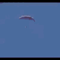a person is flying through a blue sky with a parachute attached to them