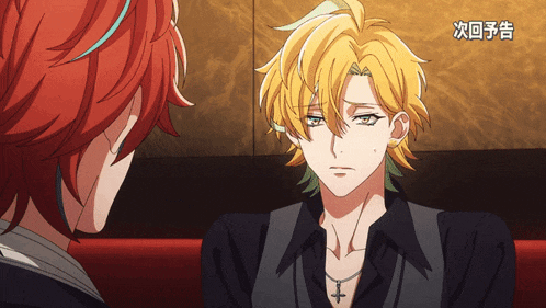a man with a cross necklace is sitting next to another man with red hair