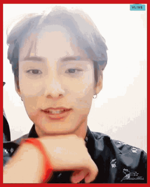 a close up of a person 's face with a red border that says vlive in the corner