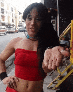 a woman in a red crop top holds out her hand