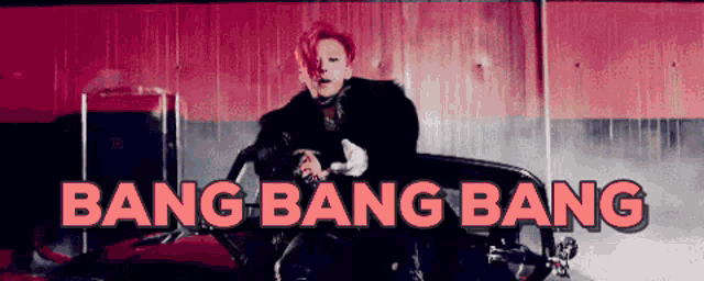 a man is sitting in a red car with the words bang bang bang above him