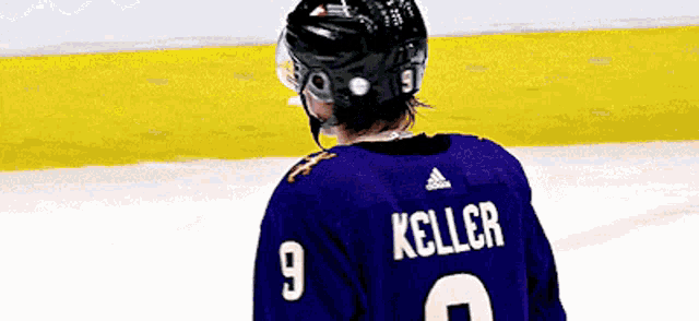 a hockey player wearing a purple jersey with the number 9 on it